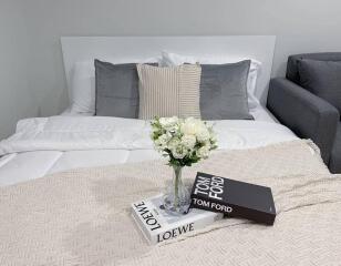 Cozy bedroom with a double bed, pillows, and a vase with flowers