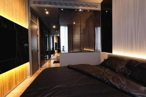 Modern bedroom with dark tones and ambient lighting