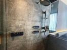 Modern bathroom with a large rain shower head and dark tiles