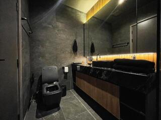 Modern bathroom with dark tiles and wooden details