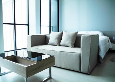 Modern living room with a beige sofa and glass coffee table