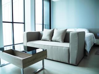 Modern living room with a beige sofa and glass coffee table