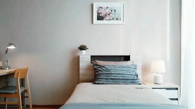 Modern bedroom with single bed, desk, and lamp