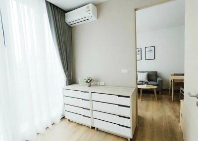 Bright bedroom with wooden flooring, dresser, and air conditioning