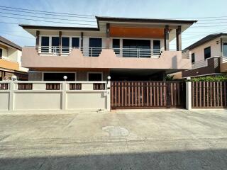 Front exterior view of a modern two-story house with a gated driveway.