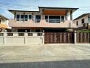 Front exterior view of a modern two-story house with a gated driveway.