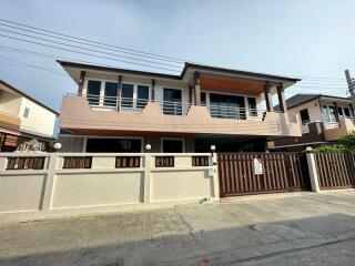 Exterior of a two-story house with a gated fence