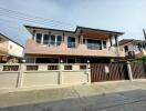 Exterior of a two-story house with a gated fence