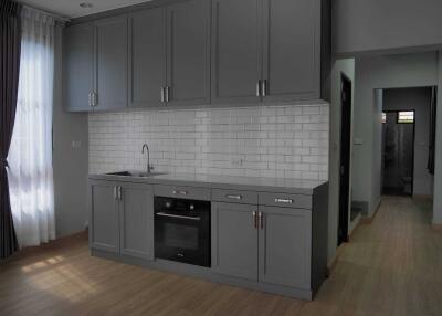 Modern kitchen with gray cabinets and a white tiled backsplash