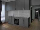 Modern kitchen with gray cabinets and a white tiled backsplash