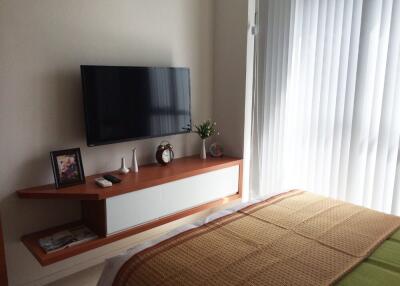 Bedroom with wall-mounted TV and a side table