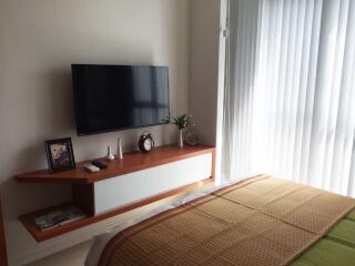 Bedroom with wall-mounted TV and a side table