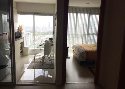 Apartment with a view of the city, showing a dining area and bedroom