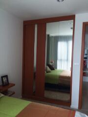 Bedroom with mirrored wardrobe and bed with green cover