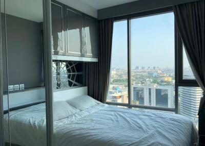 Modern bedroom with a large window and a city view