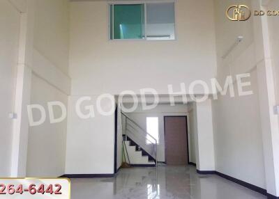 Spacious living room with high ceiling and glossy tiled floor