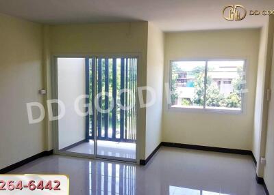 Spacious living room with large windows and sliding door to the balcony