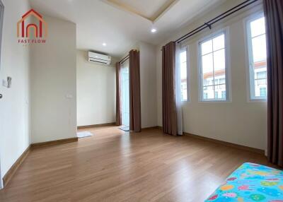 Spacious living area with wooden flooring and large windows