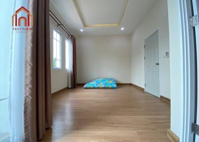 Spacious bedroom with wooden flooring and large windows