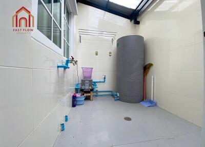 Utility room with water tank and plumbing fixtures