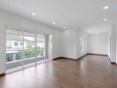 Spacious and well-lit living area with wooden flooring