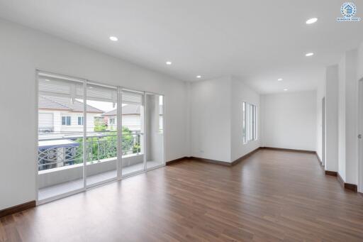 Spacious and well-lit living area with wooden flooring