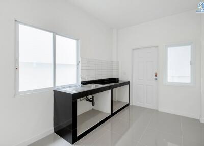 Modern minimalist kitchen with white walls and black countertop