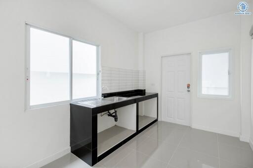 Modern minimalist kitchen with white walls and black countertop