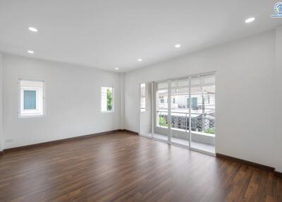 Spacious living room with wooden flooring and large windows