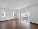 Spacious living room with wooden flooring and large windows