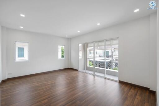 Spacious living room with wooden flooring and large windows