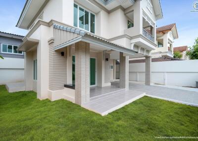 Modern two-story house with a lawn and covered entrance