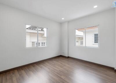 bright empty bedroom with large windows and wooden floor