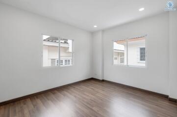 bright empty bedroom with large windows and wooden floor