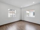 bright empty bedroom with large windows and wooden floor