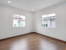 Empty bedroom with wooden flooring and large windows