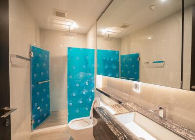 Modern bathroom with glass-enclosed shower and large mirror