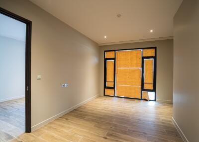 Empty living room with wooden floors and large windows