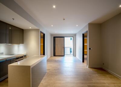 Modern open plan kitchen and living area with wooden flooring and ample lighting