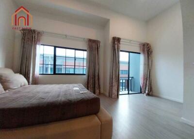 Spacious bedroom with large windows and balcony access