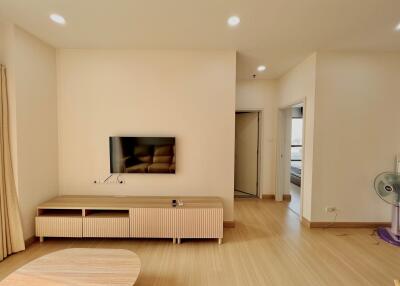 Contemporary living room with wooden furniture and wall-mounted TV