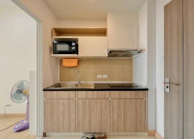 Compact kitchen with wooden cabinets and modern appliances