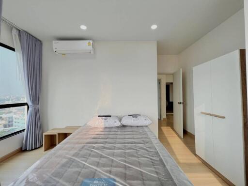 Modern bedroom with a bed, air conditioner, and wardrobe