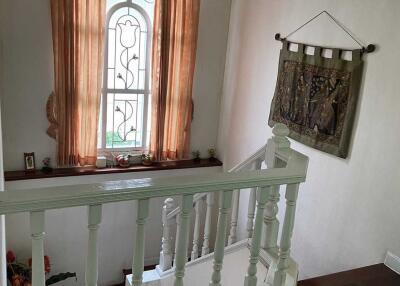 Staircase landing with window and decorative wall hanging