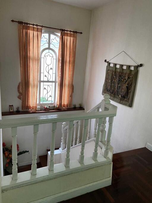 Staircase landing with window and decorative wall hanging