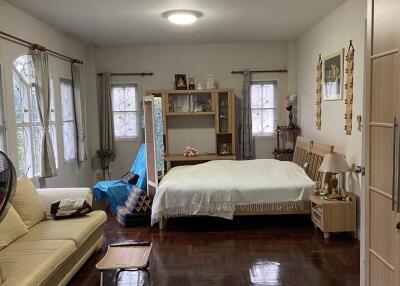 Bedroom with bed, couch, and wooden flooring