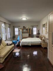 Bedroom with bed, couch, and wooden flooring