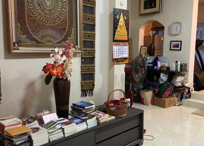 Living room with decorative artwork, books, and personal items