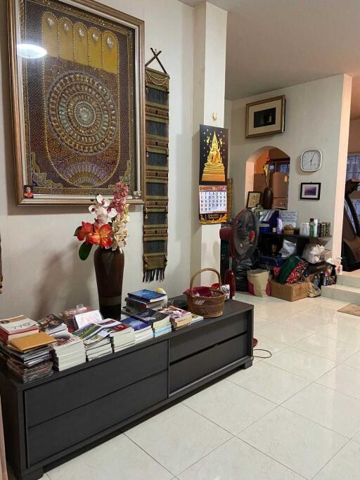 Living room with decorative artwork, books, and personal items