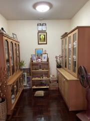 A cozy living room with wooden cabinets and a shelf displaying various items